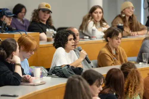 One student uses a microphone to speak during a lecture on climate change